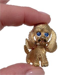 Costume puppy dog pin. Gold tone with blue crystal eyes. New.
